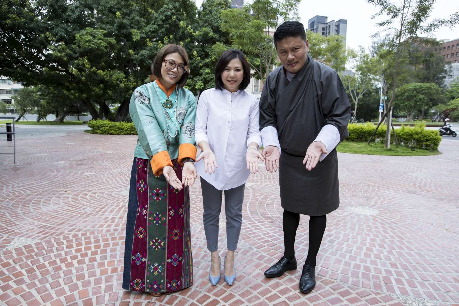 行政處長白舒樺與不丹夫妻在幸福廣場前擺出歡迎您「姑蘇三婆」的手勢